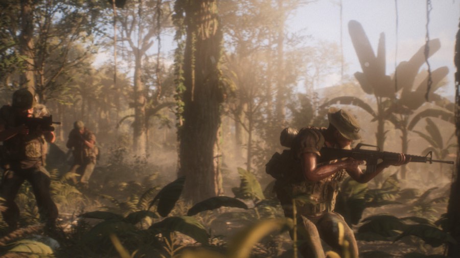US squad advancing through dense jungle with rifles raised